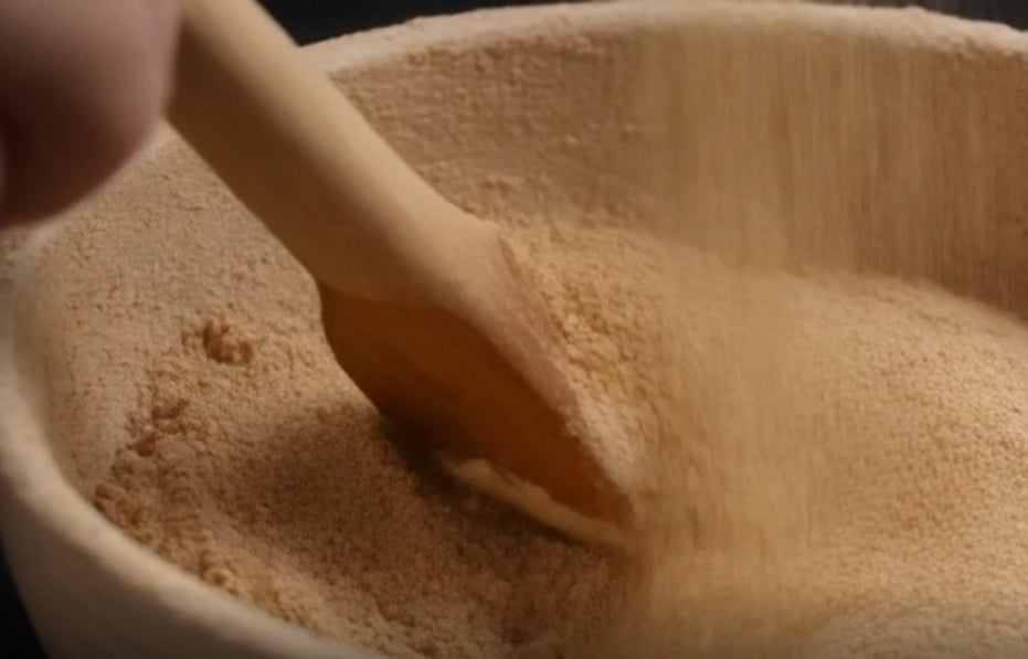 Close-up of date powder with a wooden spoon